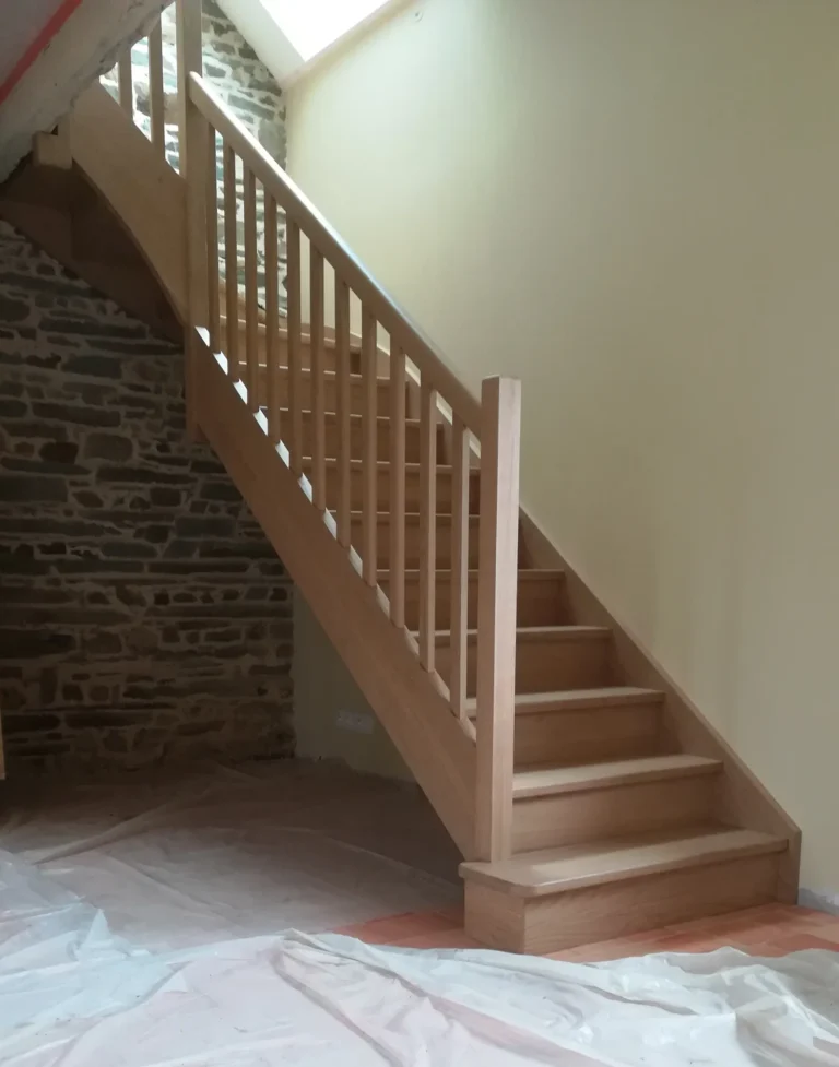 Escalier tout bois en chêne deux quart tournant posé en rénovation dans une maison en pierre bretonne fabriqué et posé par HALLOU ESCALIERS, Saint-Malo (35). |