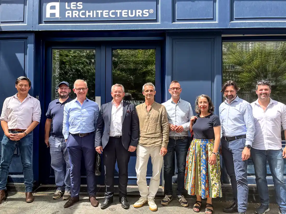 Christophe AUBIN, gérant d'HALLOU Escaliers, fabricant d'escaliers sur mesure, et Vincent GASNIER, président des Architecteurs, entourés des équipes des deux structures devant le siège du réseau Les Architecteurs à Paris.