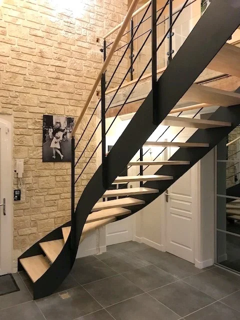 Escalier métal quart tournant bas à deux limons acier noir thermolaqué, marches en hêtre massif, garde-corps barres horizontales et main courante bois, posé dans une maison de caractère en pierre de taille à Bruz (35). — HALLOU ESCALIERS, Bruz (35).