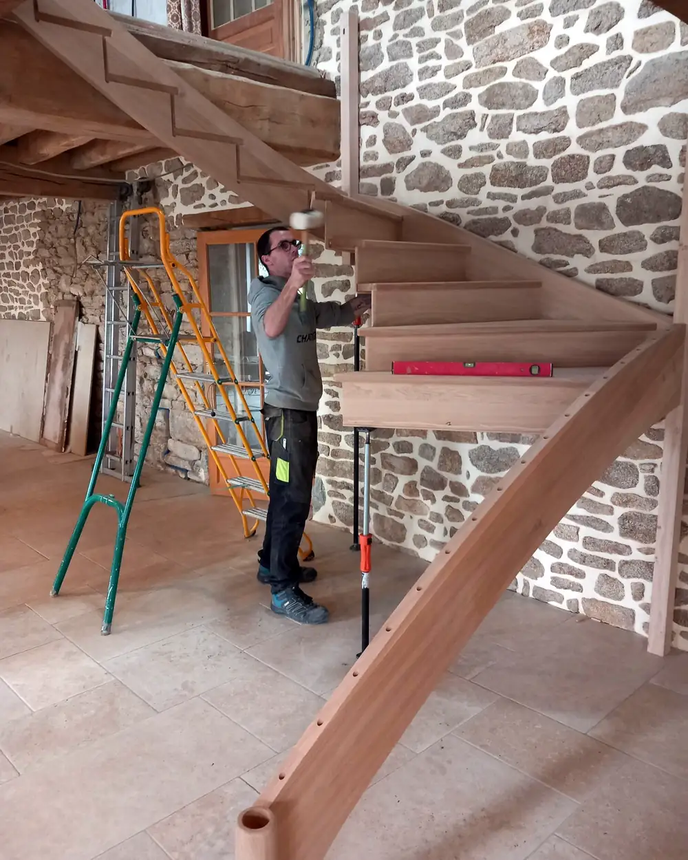 Hallou Escalliers Emboîtement des marches d'un escalier en chêne au maillet pendant la pose
