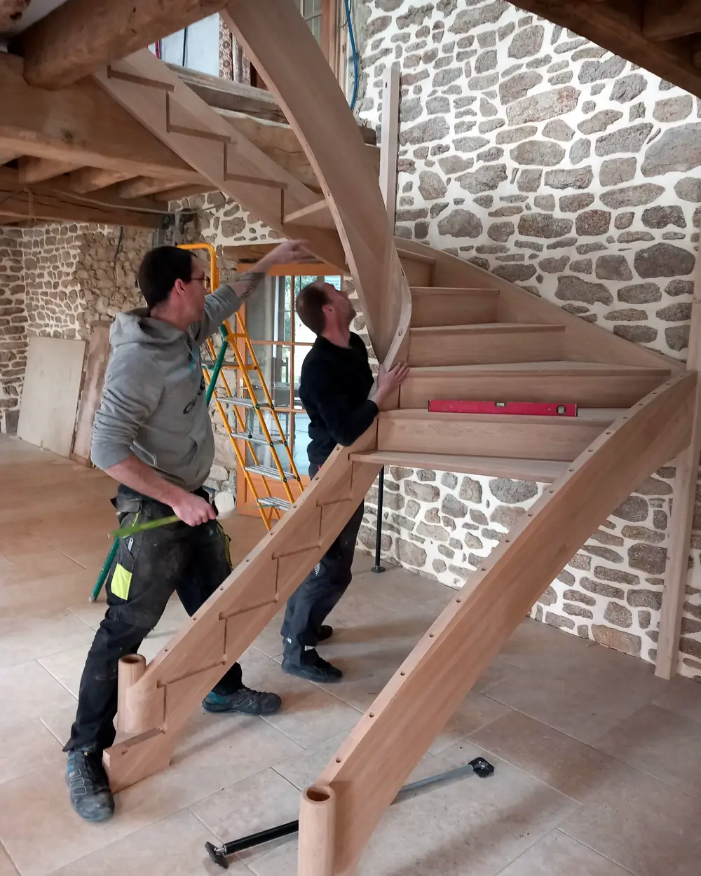 Poseurs HALLOU Escaliers ajustant le limon débillardé d'un escalier tournant